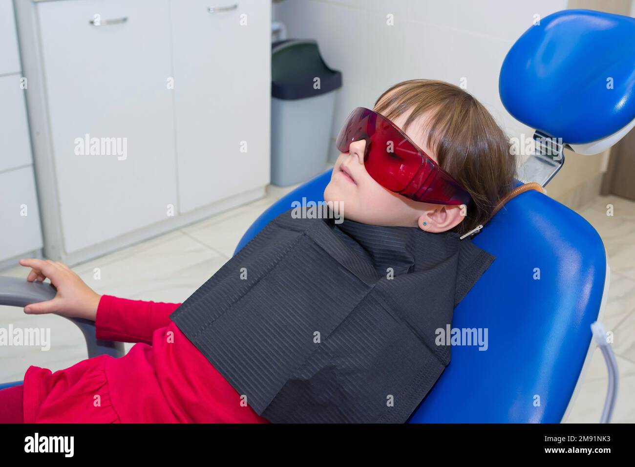 Child patient in goggles, sitting in the dental chair Stock Photo