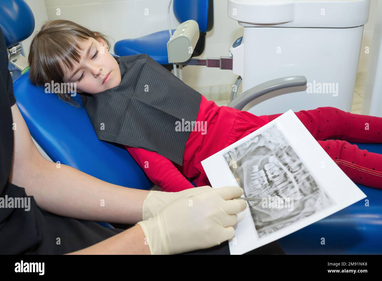 A dentist and a child patient are looking on dental X-rays Stock Photo ...