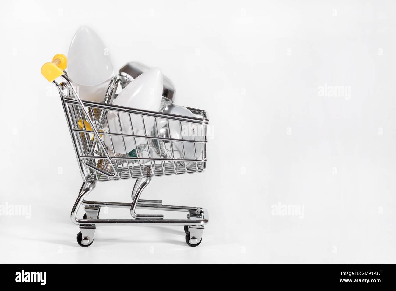 A cart full with energy saving light bulbs at the white background ...