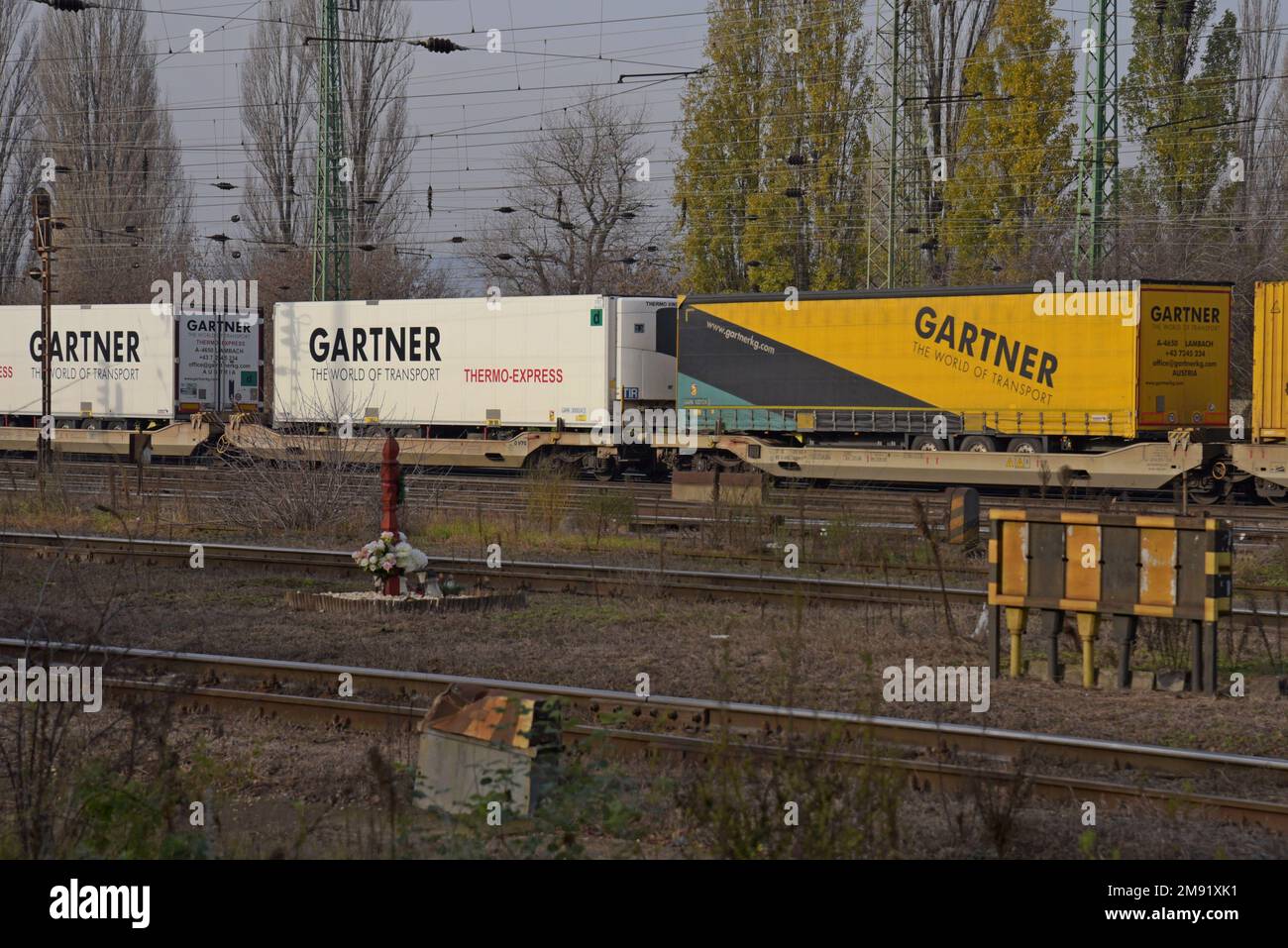 Articulated lorry trailers carried with shipping containers on a freight train designed to carry cargo of artic trucks & containers. Budapest Dec 2022 Stock Photo
