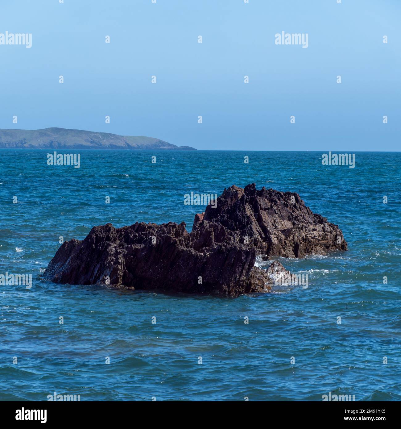 A huge stone rock among the blue sea waters. Seaside landscape, rocky ...