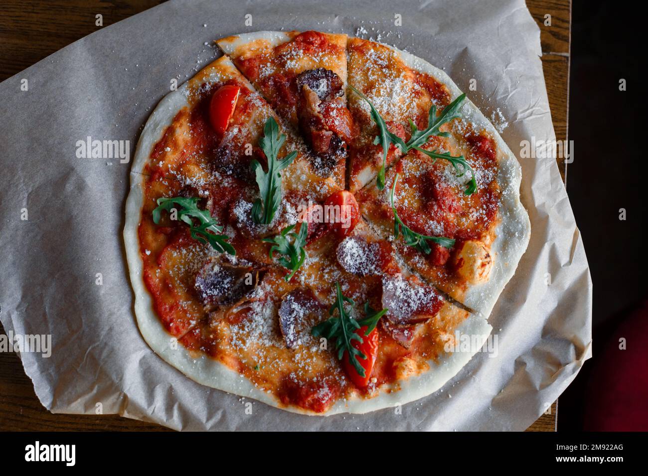 Spicy pizza with sausages and chili peppers. On a black stone background. Free space for text. High quality photo Stock Photo