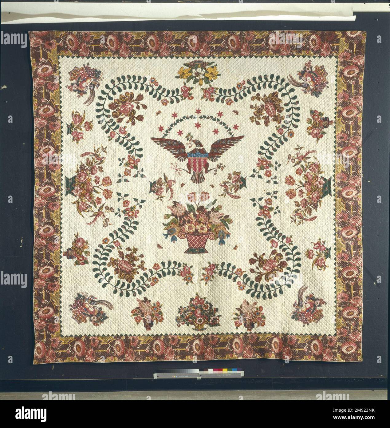 Medallion Quilt Elizabeth Welsh (American, active early 19th century). Medallion Quilt, ca. 1830. Cotton, 110 1/2 x 109 in. (280.7 x 276.9 cm).  Elizabeth Welsh’s use of reverse appliqué, in which the fabric that provides the ground for a design is meticulously cut away from the decorative elements that lie below, shows the care that went into creating this patriotic medallion quilt. Since several nearly identical quilts have been attributed to the Baltimore area, it is likely that Welsh had a connection to this region through friends or relatives. In advance of the national Bicentennial in 19 Stock Photo