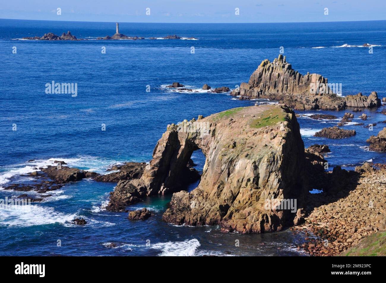 View towards the Longships lighthouse off Lands End in Cornwall, from the South West Coast path with Enys Dodnan and the Armed Knight rocks in the for Stock Photo