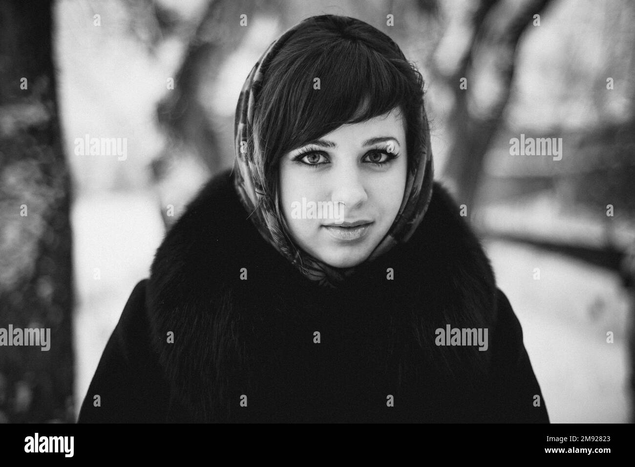 black and white portrait of a girl in a shawl in the winter in the woods Stock Photo