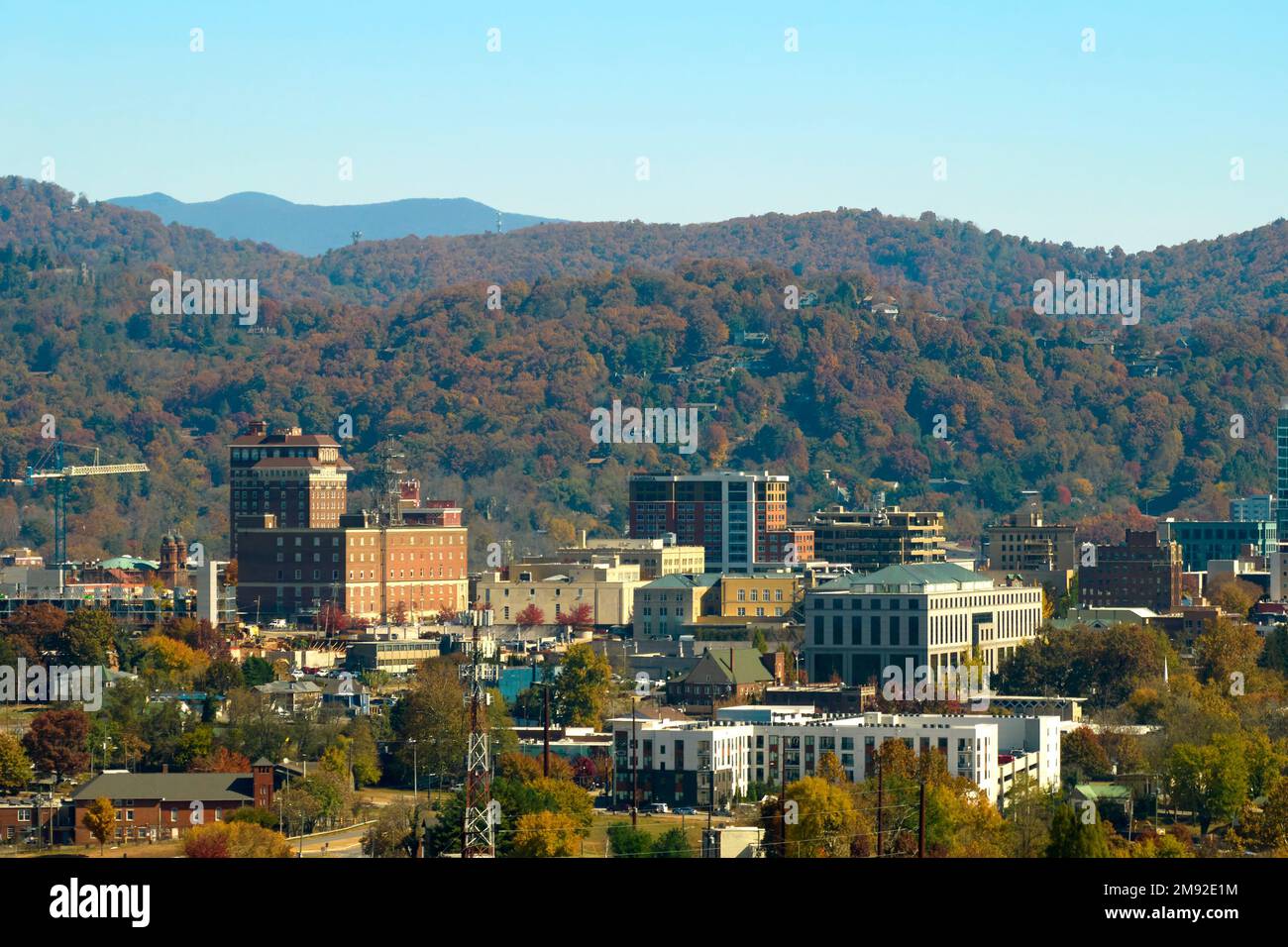 Aerial view of Asheville city in North Carolina with high buildings and mountain hills in
