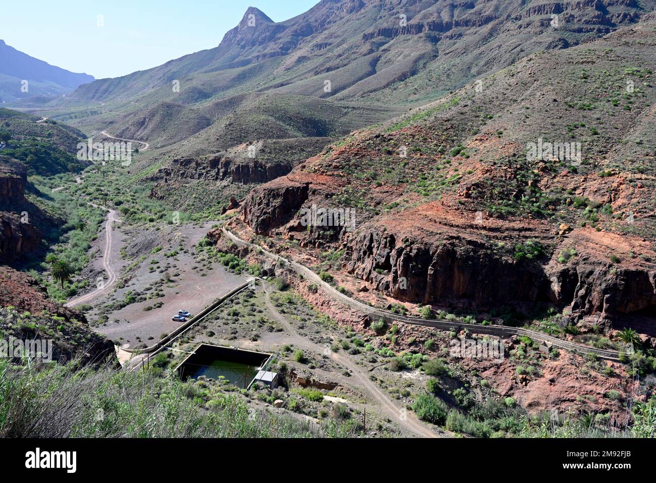 Looking down the gorge and valley of Barranco de Fataga near the small reservoir “Embalse de Fataga”, with old old aqueduct, Gran Canaria Stock Photo