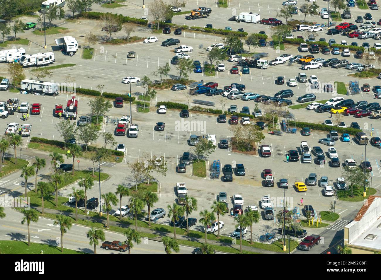 Aerial view of large parking lot with many parked colorful cars. Carpark at supercenter shopping