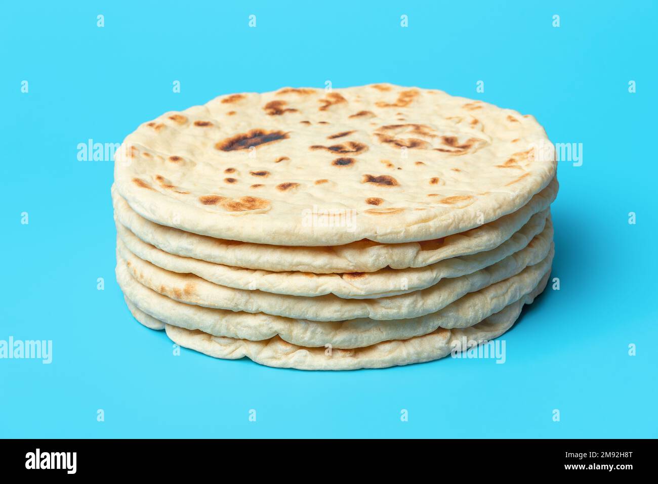 Stack of indian flatbreads minimalist on a blue table. Homemade naan