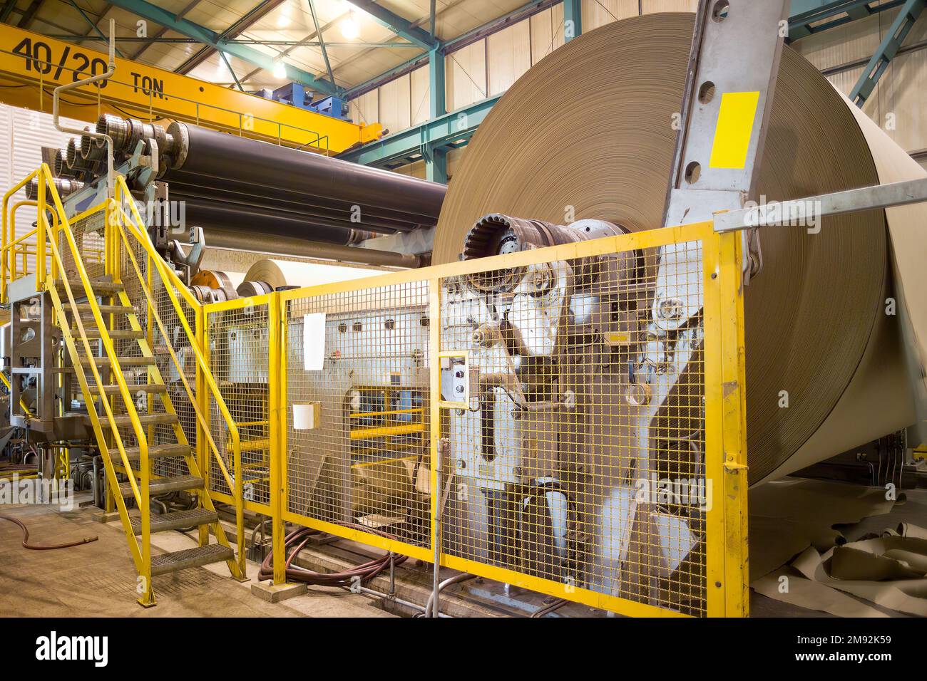 Big rolls of cardboard and paper coming out of the machinery in a paper mill plant in Chile. Stock Photo