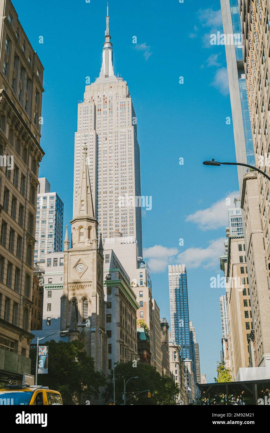 From below Empire State Building in New York City against blue sky ...