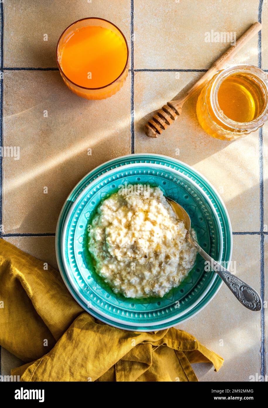 From above healthy breakfast with oat porridge and honey on tiled ...