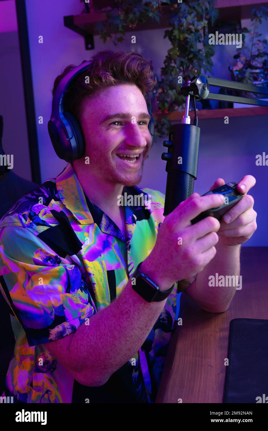 Gamer Using Mic Side view of positive young male gamer in colorful shirt and wireless ...