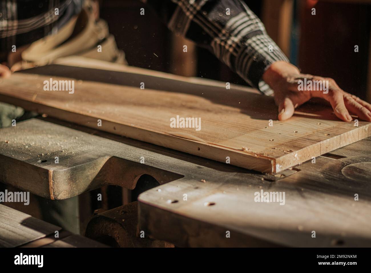 Unrecognizable male carpenter in casual shirt preparing wooden board ...