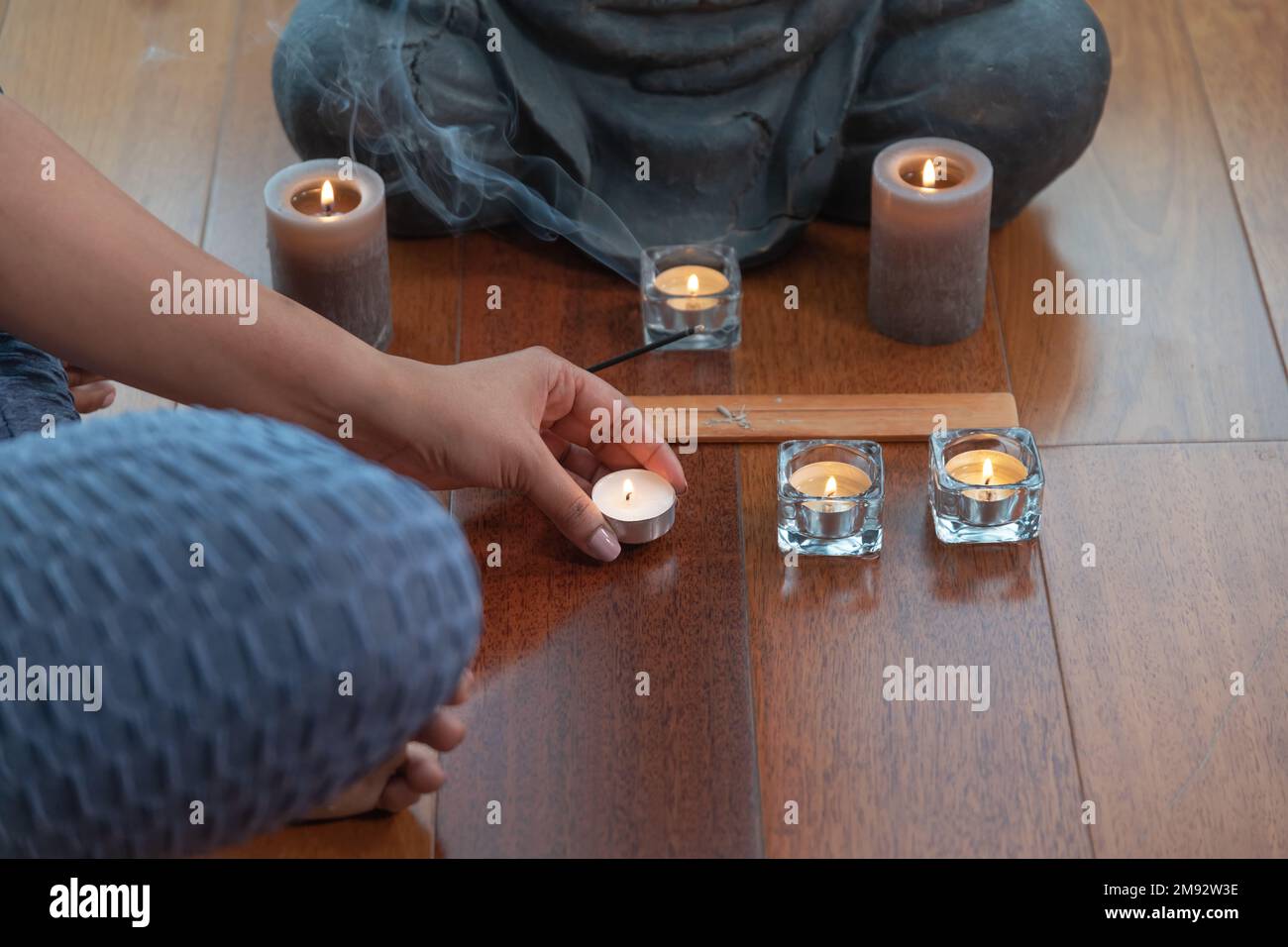 Crop anonymous woman with curly hair sitting on floor with candle near Buddha statue during worship Stock Photo - Alamy Crop anonymous woman with curly hair sitting on floor with candle near Buddha statue during worship Stock Photo - Alamy
