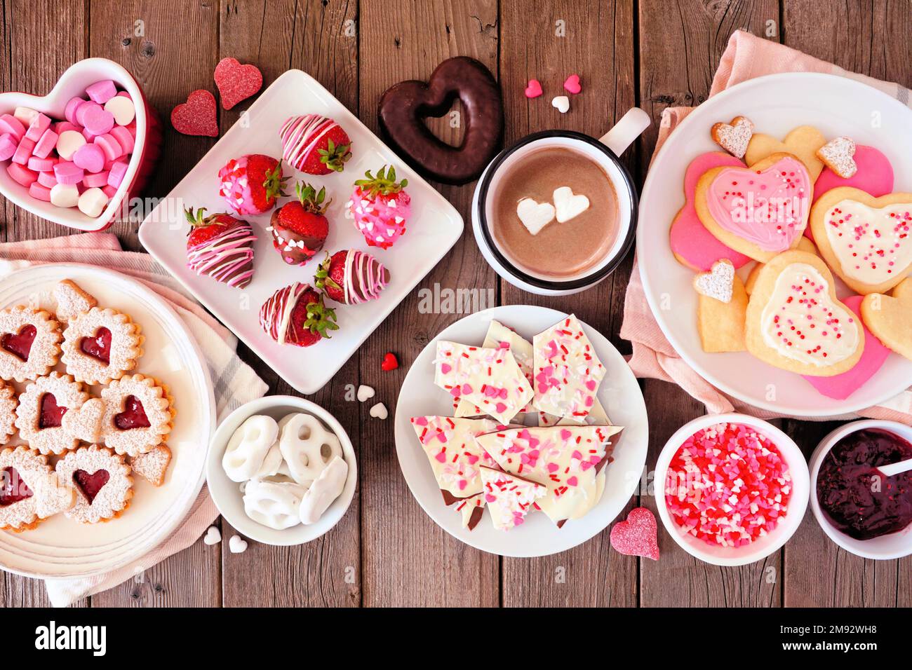 Valentines Day table scene of assorted sweets and cookies. Top view over a rustic wood background. Love and hearts theme. Stock Photo