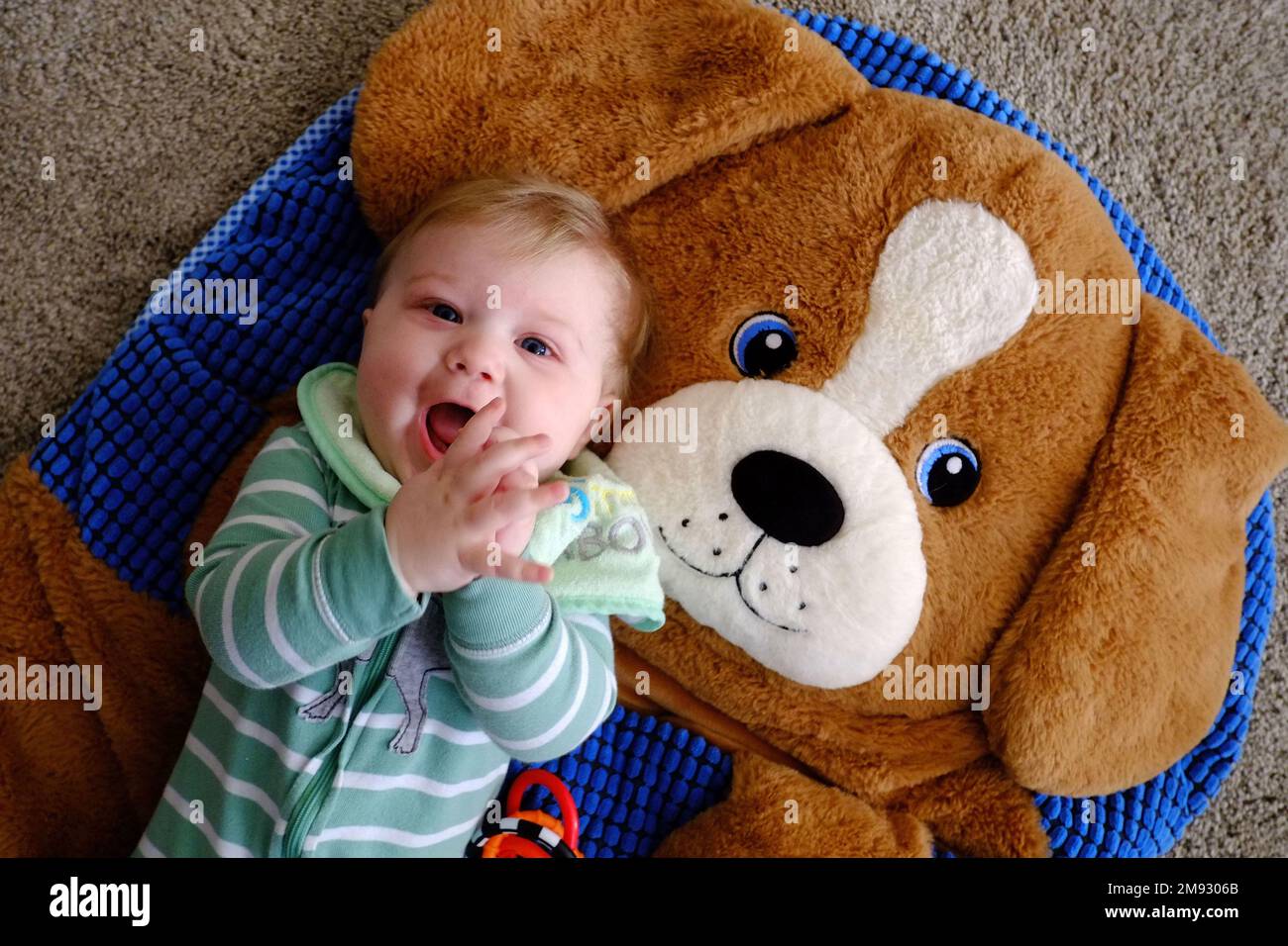 An eightmonthold baby lying on a furry blanket with a furry dog face