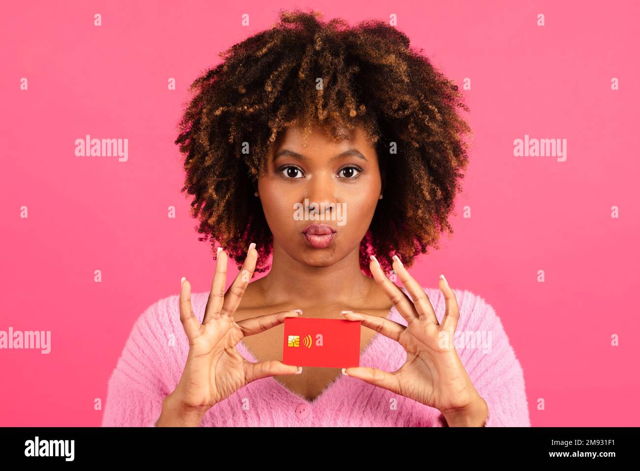 Cheerful millennial african american curly female shopaholic show credit card look at camera Stock Photo