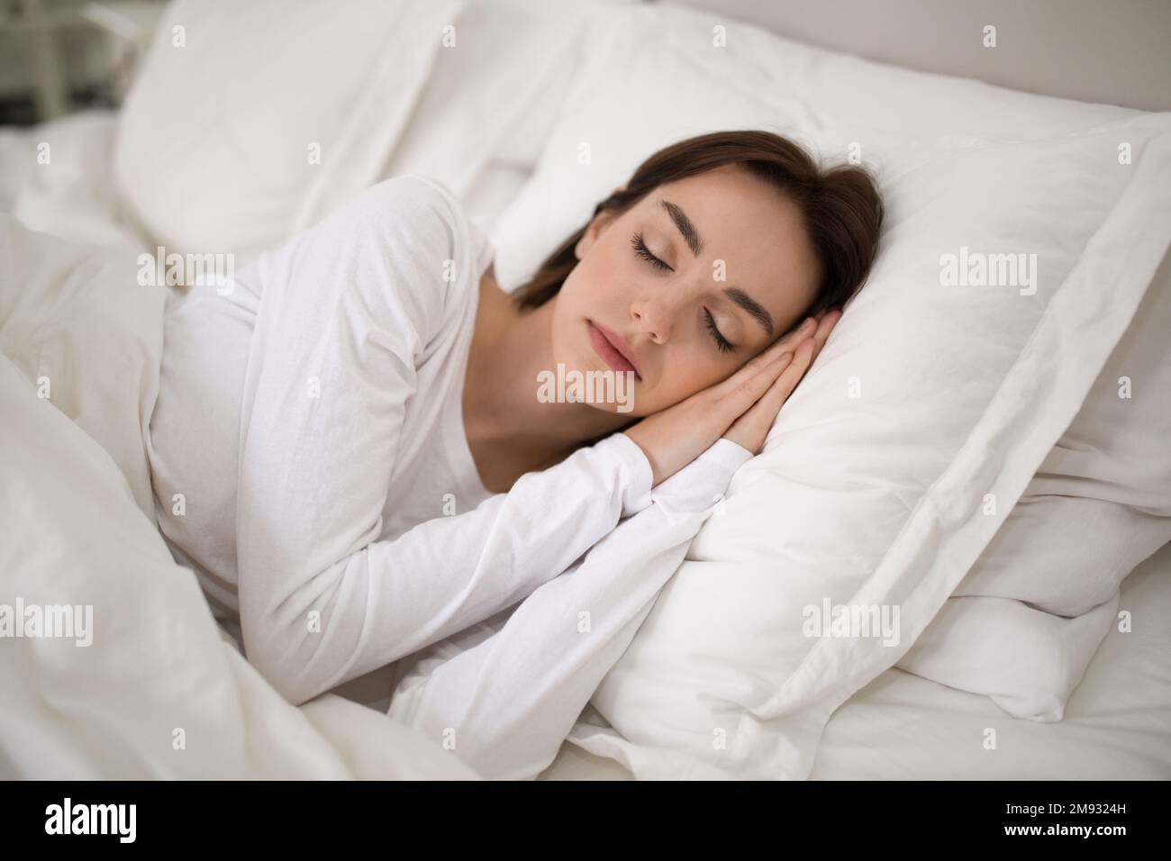 Young lady sleeping with hands under her head Stock Photo