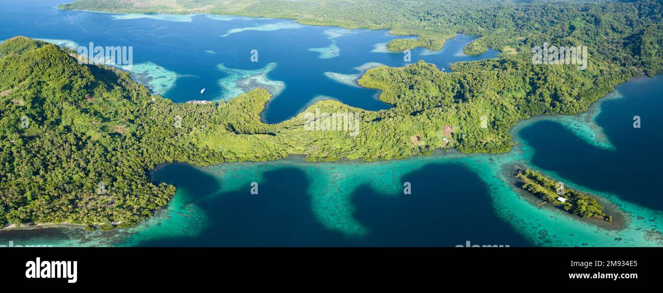 Coral reefs fringe convoluted, tropical islands found in a remote part of the Solomon Islands. This country harbors extraordinary marine biodiversity. Stock Photo