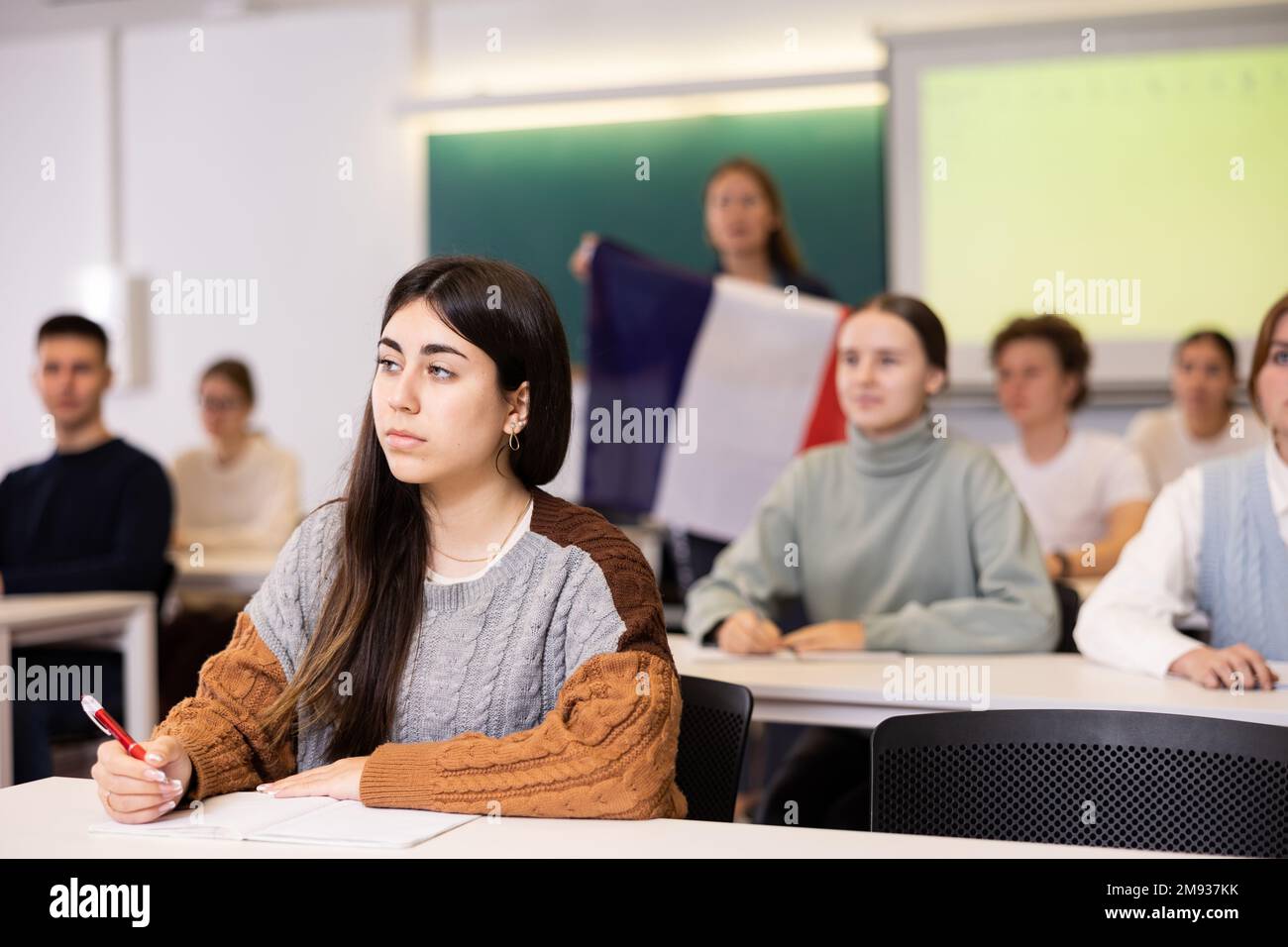 Geography lesson in school class teacher talks about France, holding