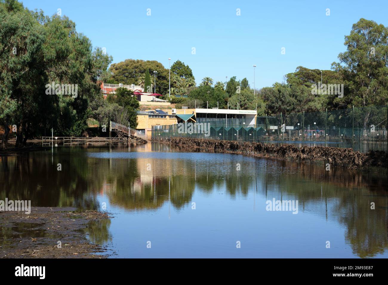 Mildura tennis courts an surrounds covered in flood waters, during the 2022-23 flooding event. Debris can be seen caught in fences and the clubhouse i Stock Photo