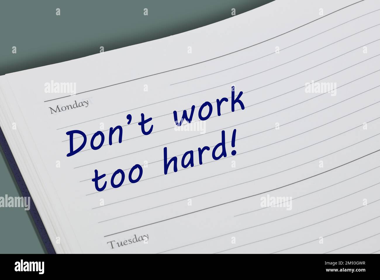 Dont work too hard advice note in a diary page Stock Photo