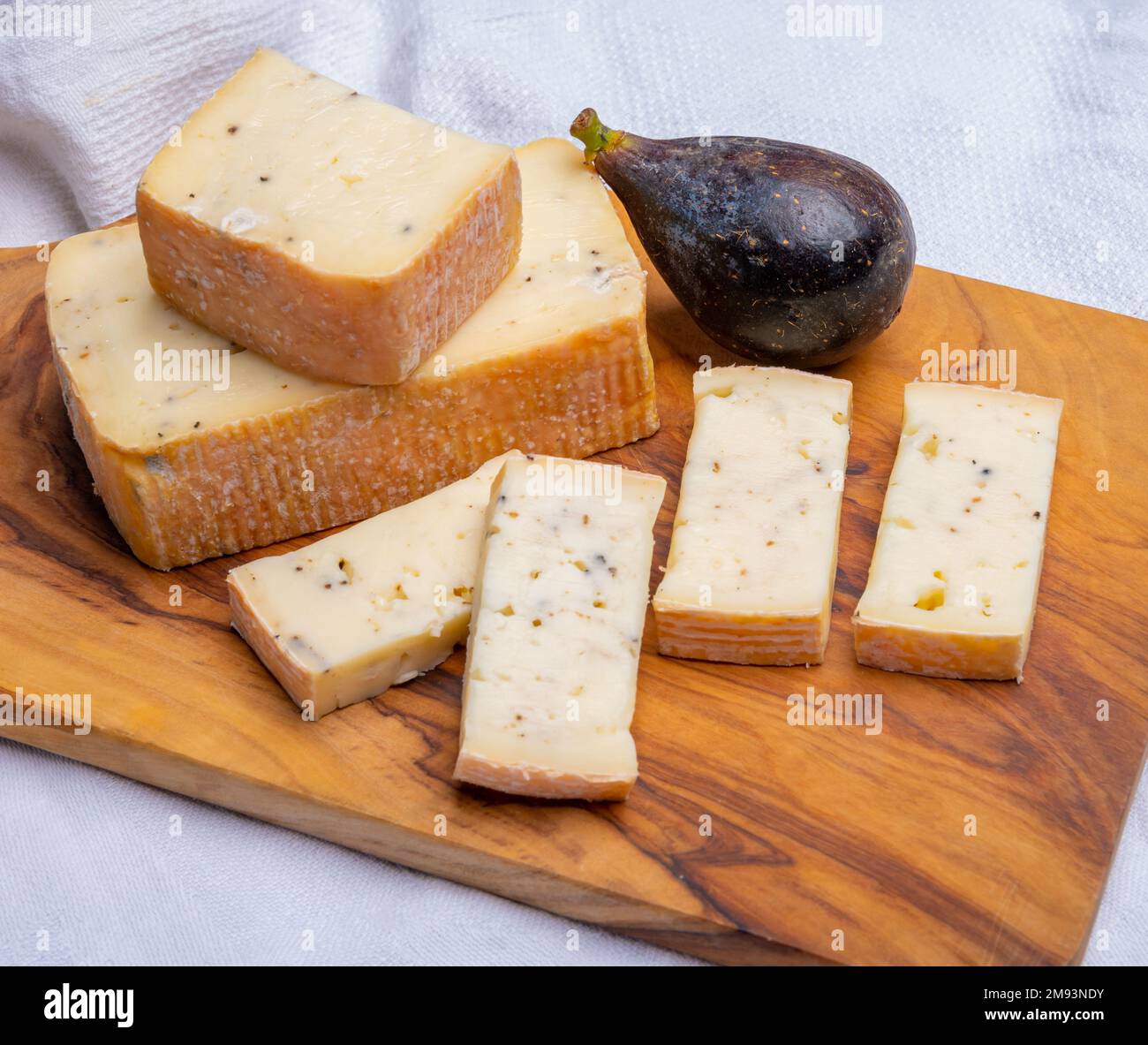Italian cheese collection, yellow taleggio cheese with black truffles ...