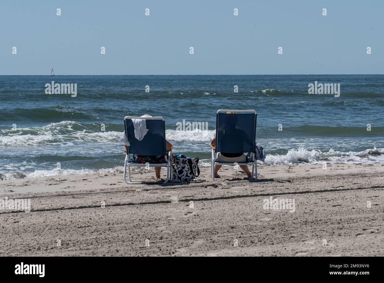 Avalon, New Jersey, June 6, 2022: Summer vacation at the Jersey Shore. Summer vacationers enjoy sitting in lounge chairs relaxing on the beach in Aval Stock Photo