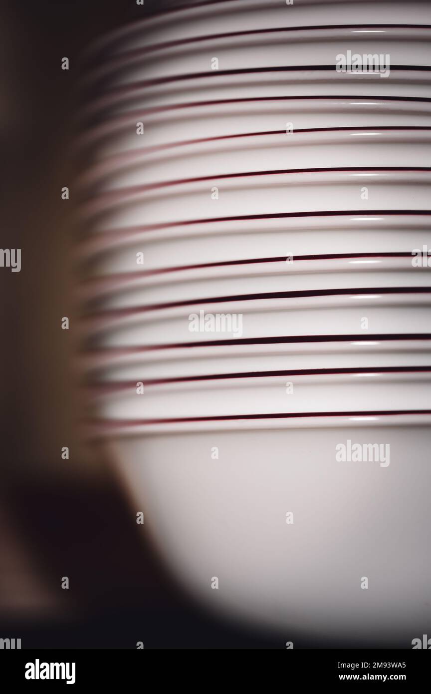 Narrow depth of field picture of an open kitchen stacked ceramic plates and bowls Stock
