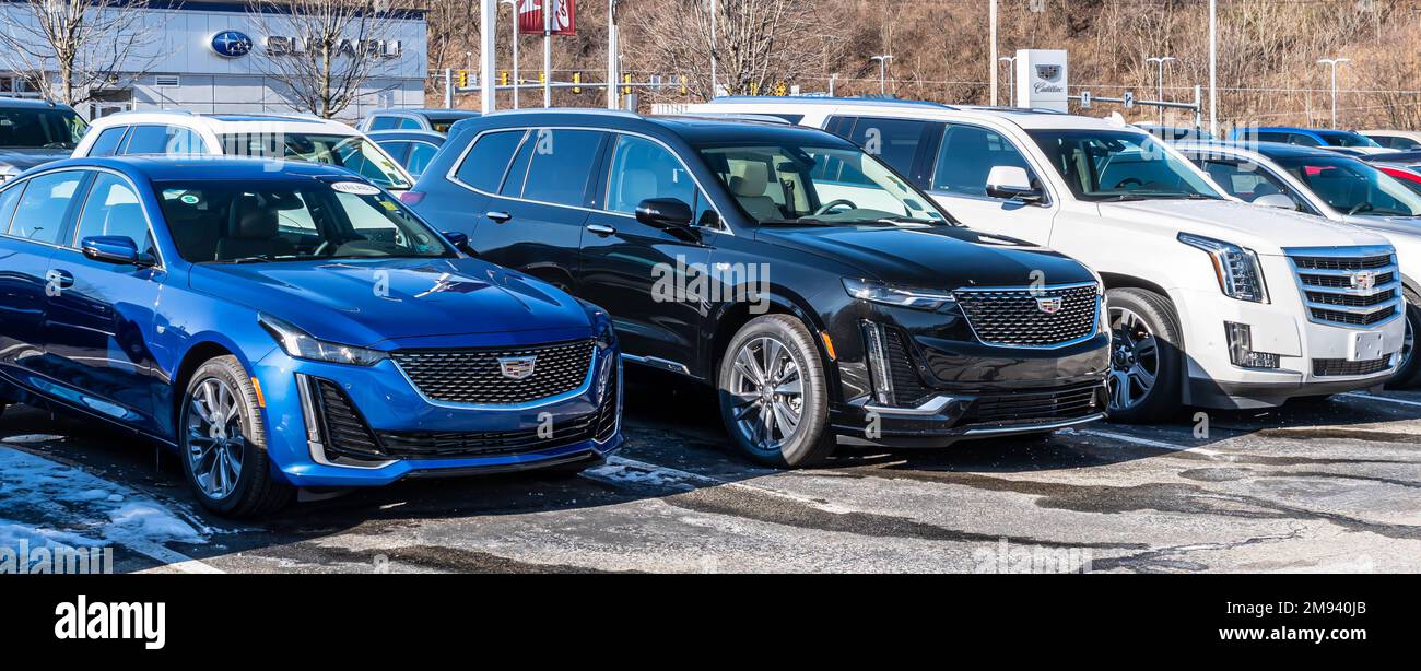 Three different Cadillacs lined up for sale at a dealership in