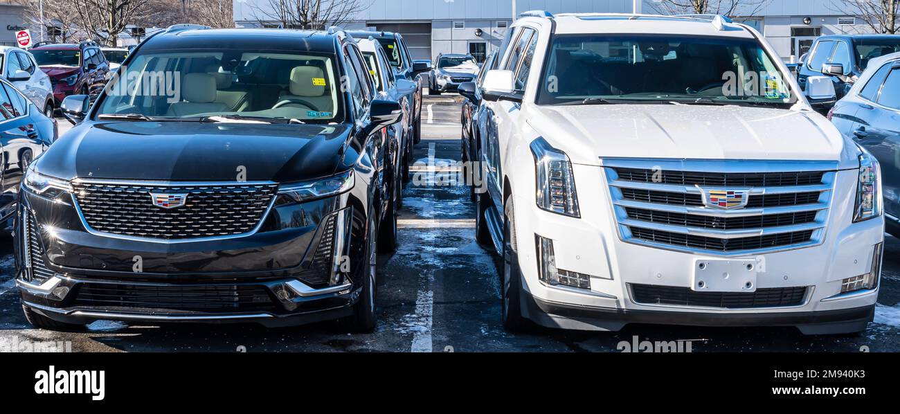 Two used Cadillac SUVs, one white and the other black for sale at a
