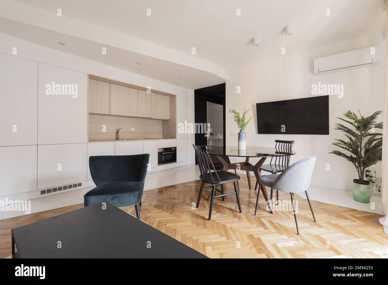 Studio apartment with openplan kitchen, round glass dining table and