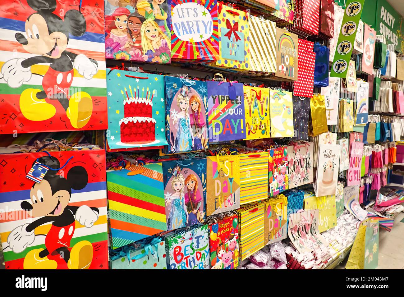 Store display of colourful gift bags hanging on a wall - party supplies. Metro Vancouver, B. C., Canada. Stock Photo