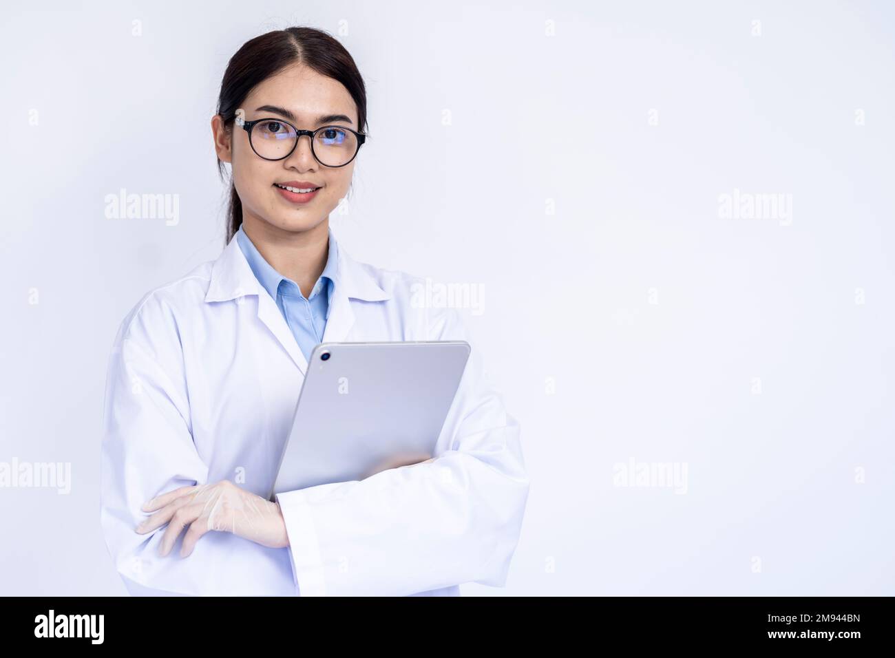 Portrait of female doctor in medical coat standing on isolated white background Stock Photo