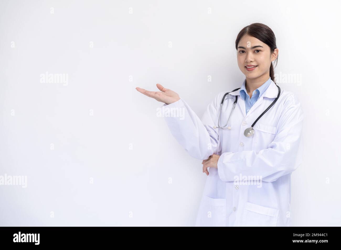 Portrait of female doctor in medical coat standing on isolated white background Stock Photo