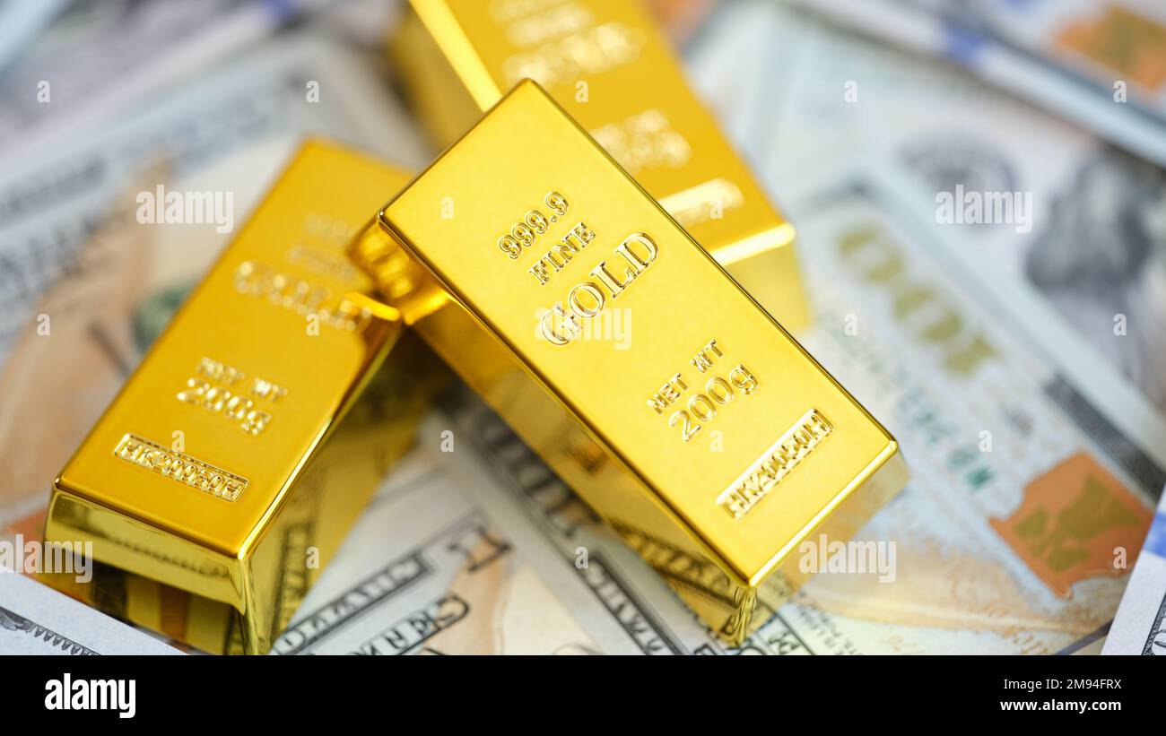 Close up of gold bars on many US dollar bills. Stock Photo
