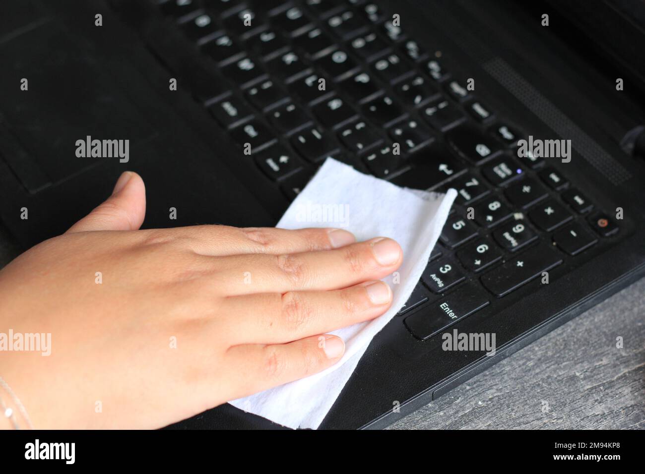 Clean computer keyboard with antibacterial wet towel, virus prevention