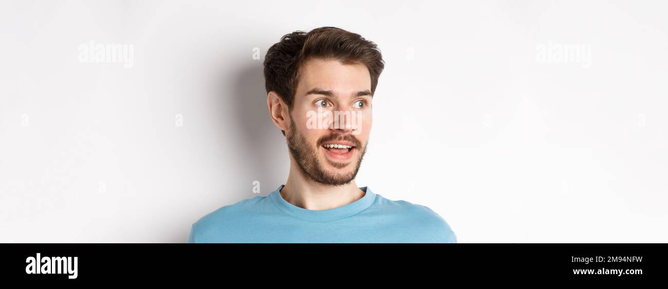 Close-up of surprised and excited bearded man, looking left with opened ...