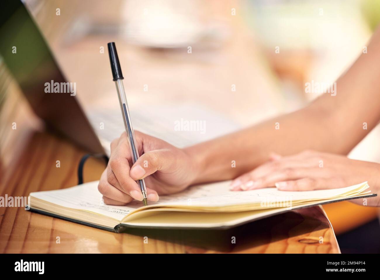 Theres always more paperwork. a nursery owner using a laptop and making notes. Stock Photo