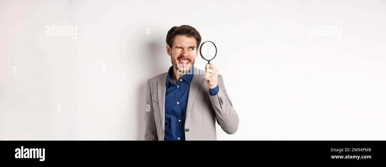 Funny guy in suit investigating or searching for something, looking