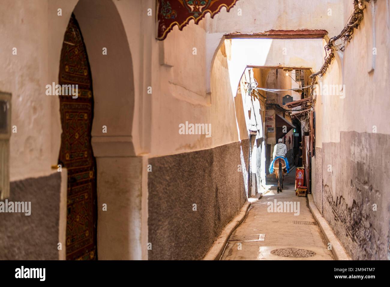 Arabic man on donkey at narrow streets of medina in Fes, Morocco, North Africa Stock Photo