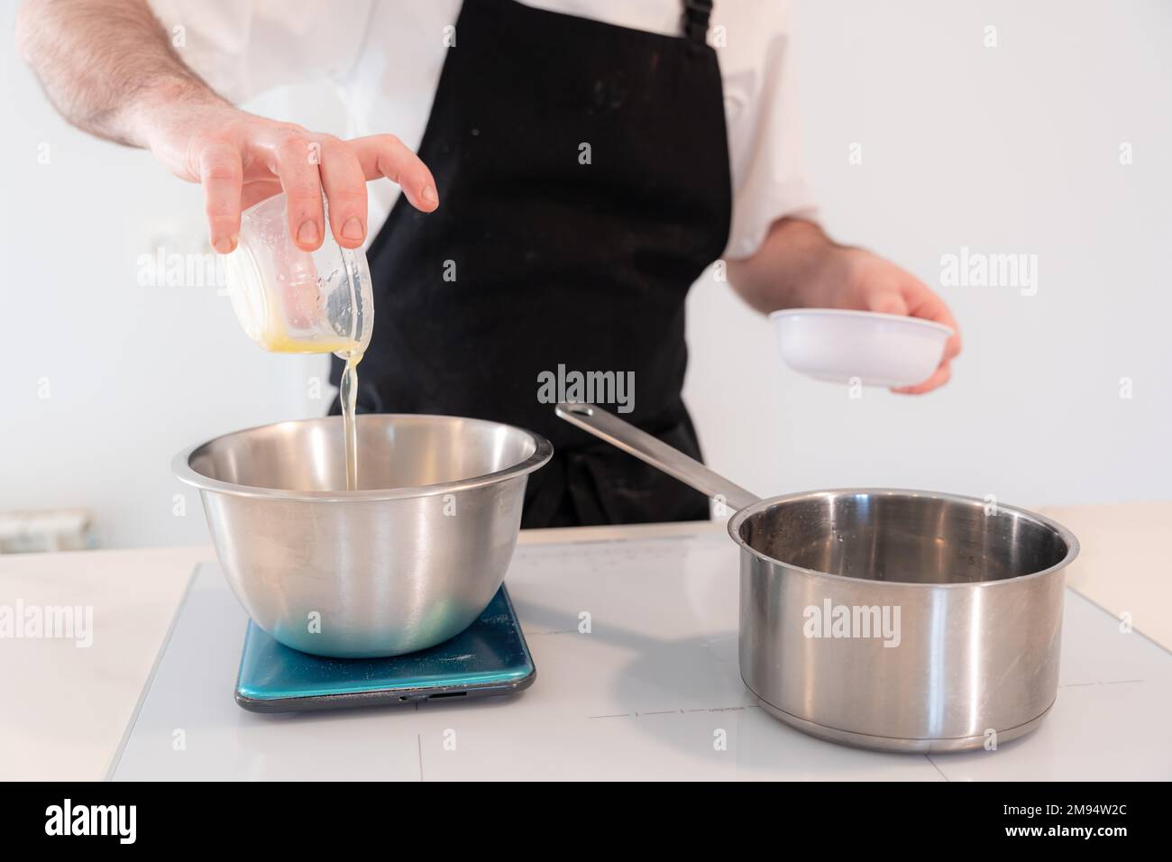 Hands of a man cooking a red velvet cake at home, preparing Swiss