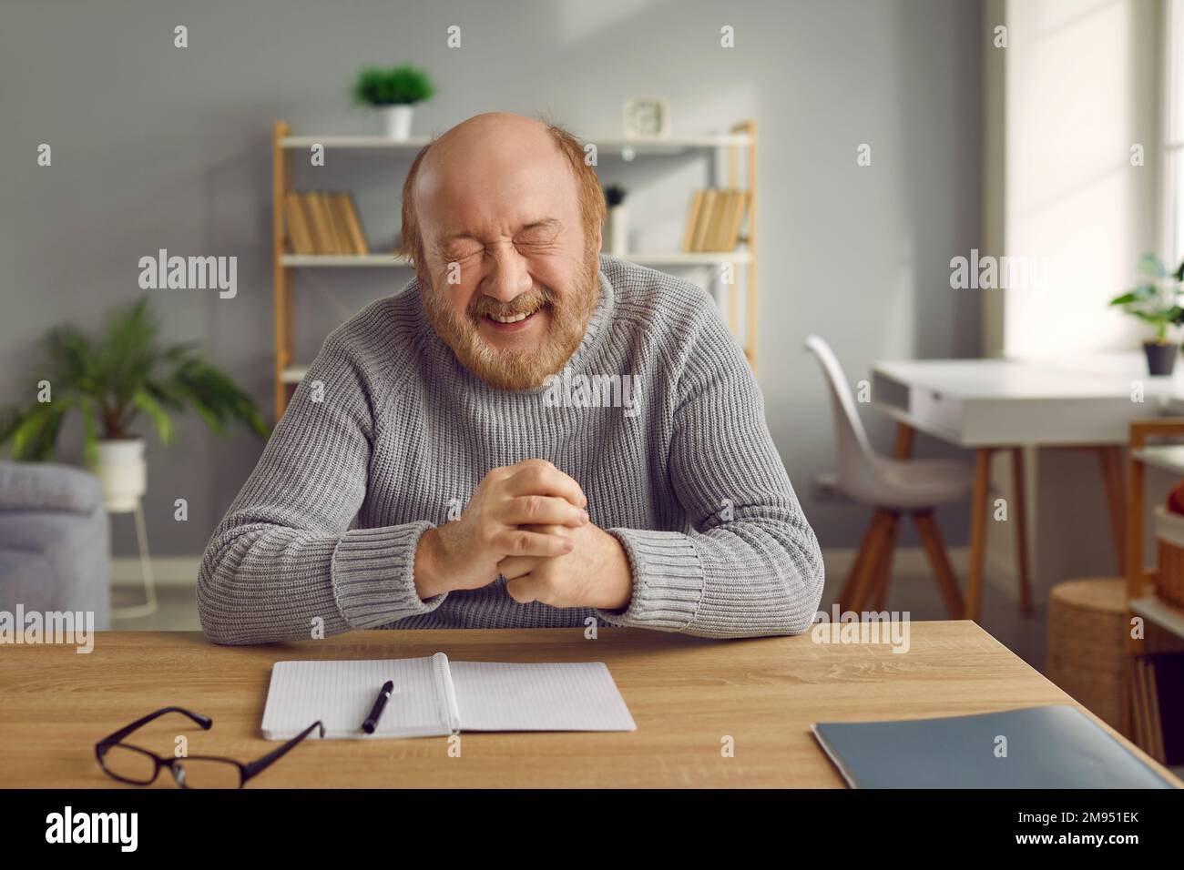 Happy smiling senior man sitting at table at home Stock Photo