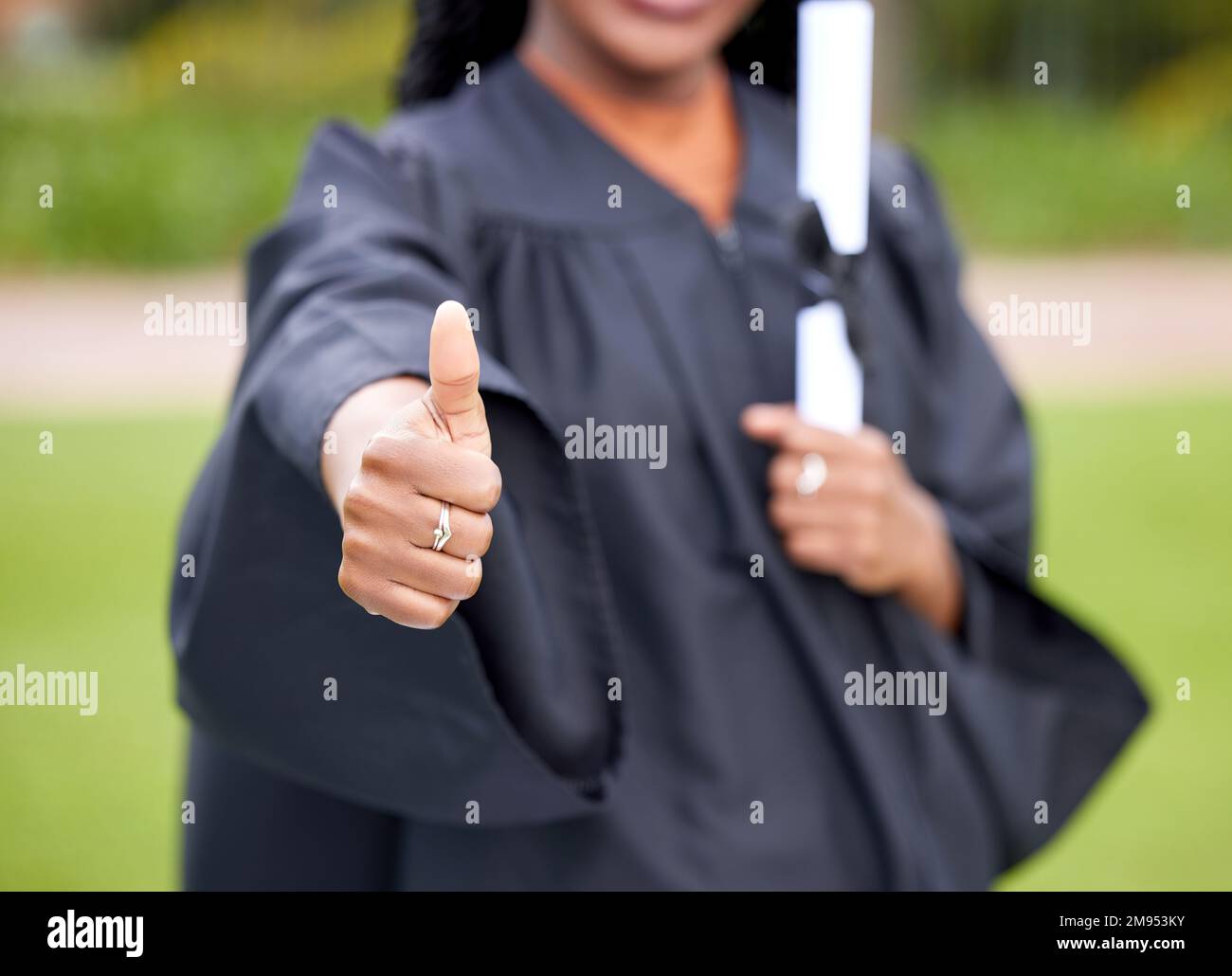 Congratulations, you made it. Closeup shot of an unrecognisable woman showing thumbs up on graduation day. Stock Photo