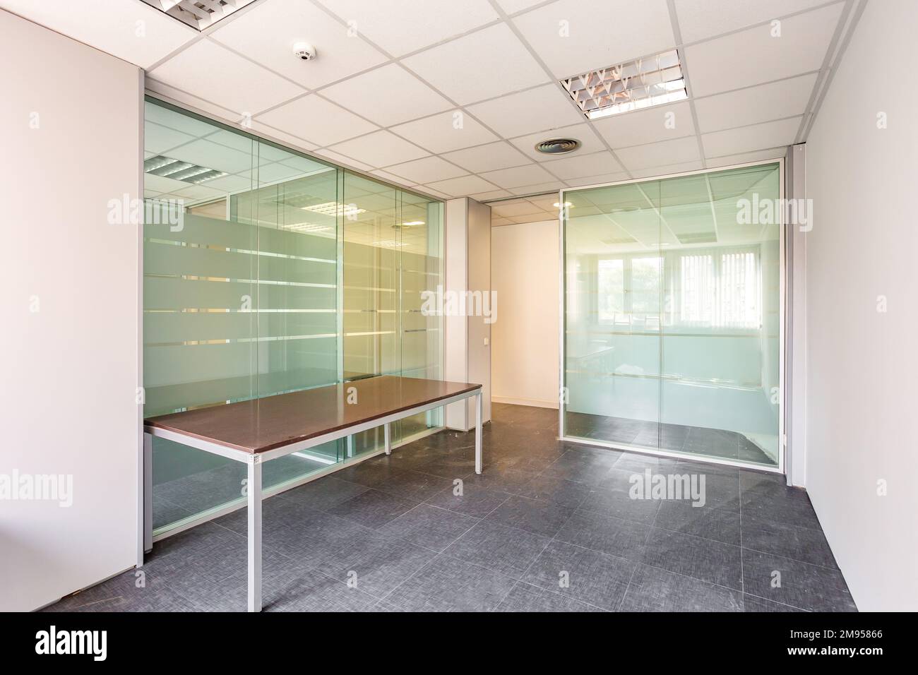 An empty room with clear, durable glass wall panels are ideal for dividing a large space into individual offices. Glass panels are the best solution Stock Photo