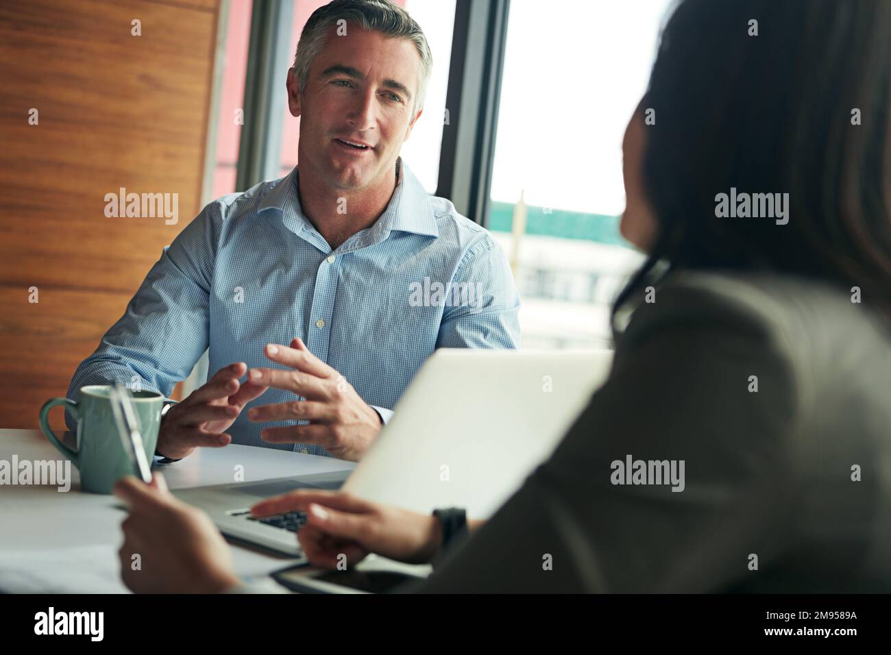 Business meeting, discussion and man and woman with laptop working on planning, goals and mission. Teamwork, collaboration and worker talking to Stock Photo