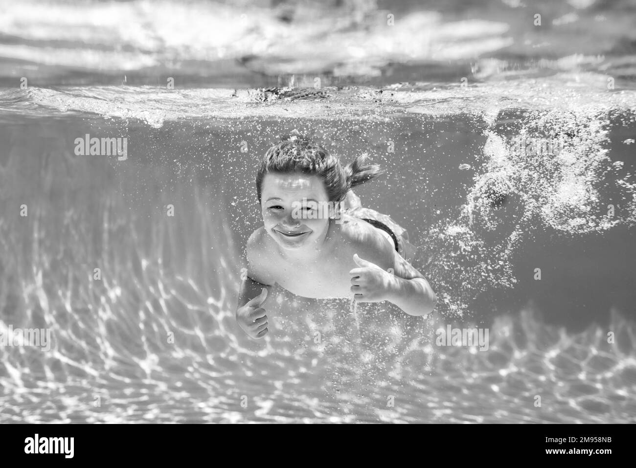 Boy kid swim and dive underwater. Under water portrait in swim pool
