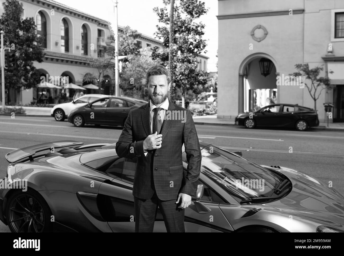 confident business man rent car. ceo stand by luxury automobile