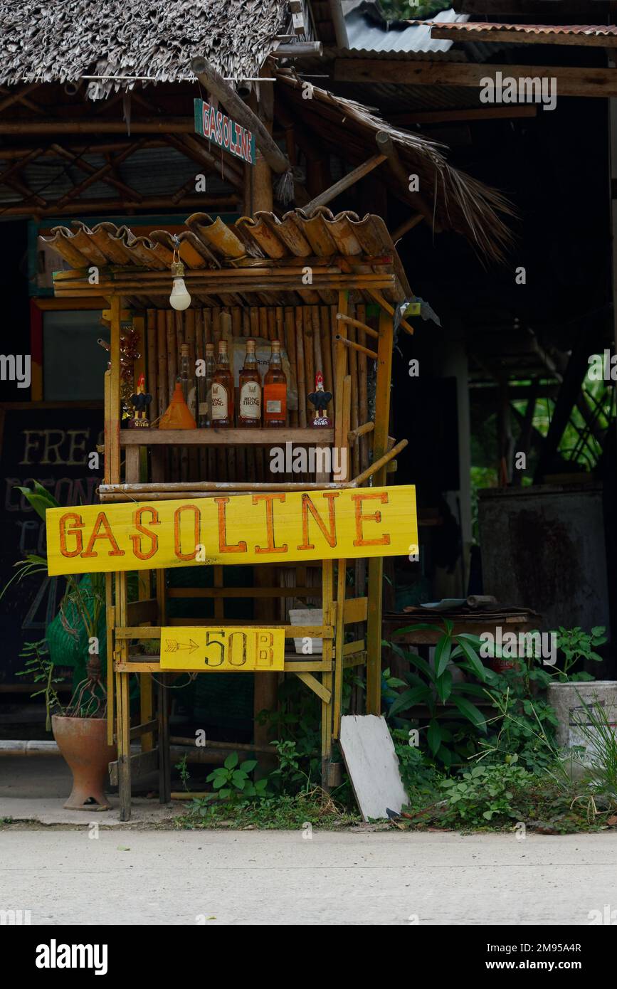 A vertical shot of a gas station with a red sign and bottles of